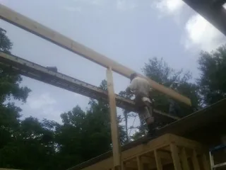 Carpenter setting a ridge beam over a new addition frame — Ice Dam Removal by Roofing Brothers in Nanuet
