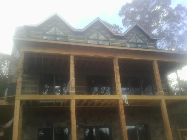 Dormers and porch framing on a large log home under construction — Roof Coating work by our crew in Nanuet