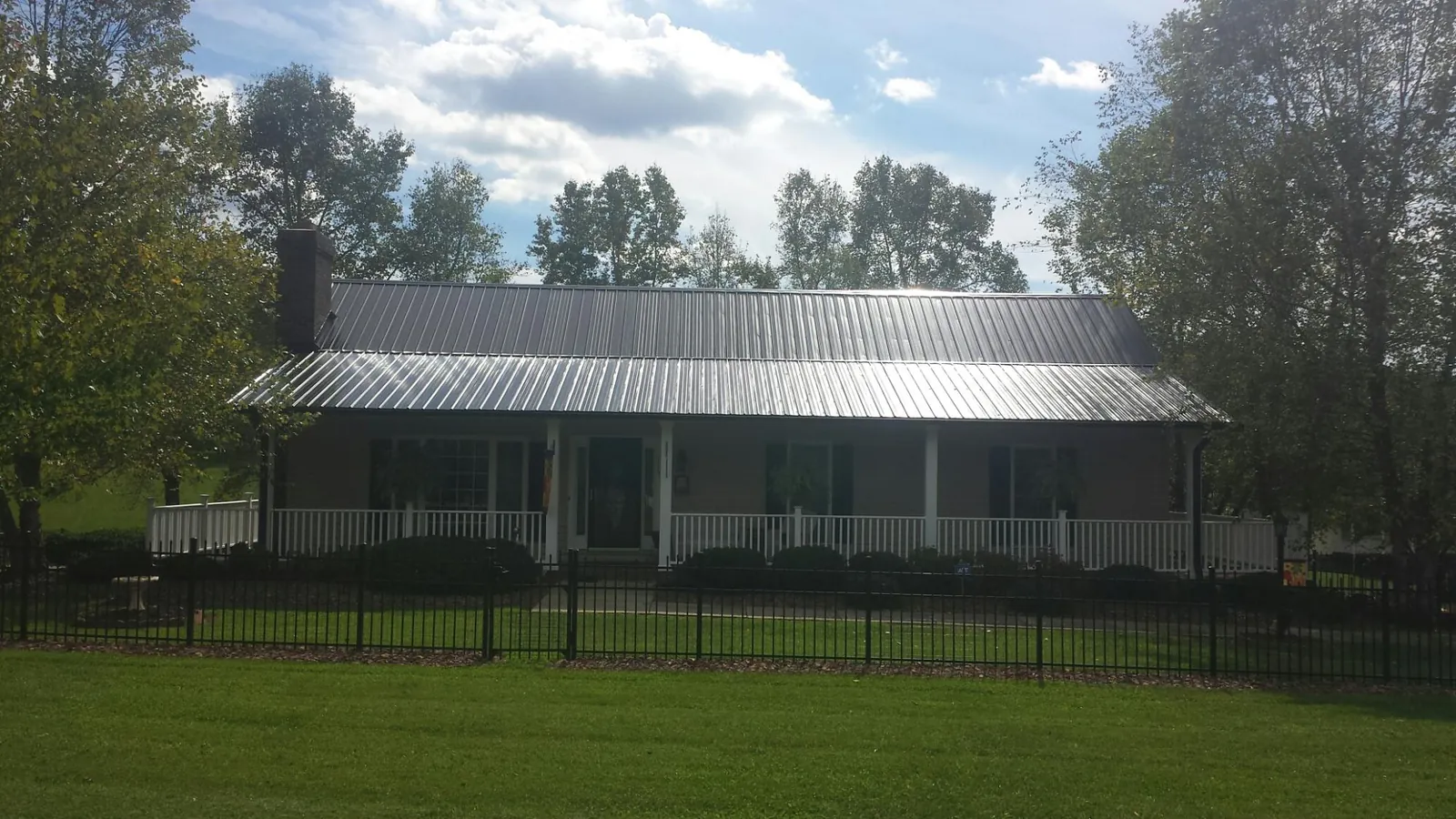 Gray metal roof on a brick ranch with a full width front porch — Gutter Guard Installation work by our crew in Nanuet