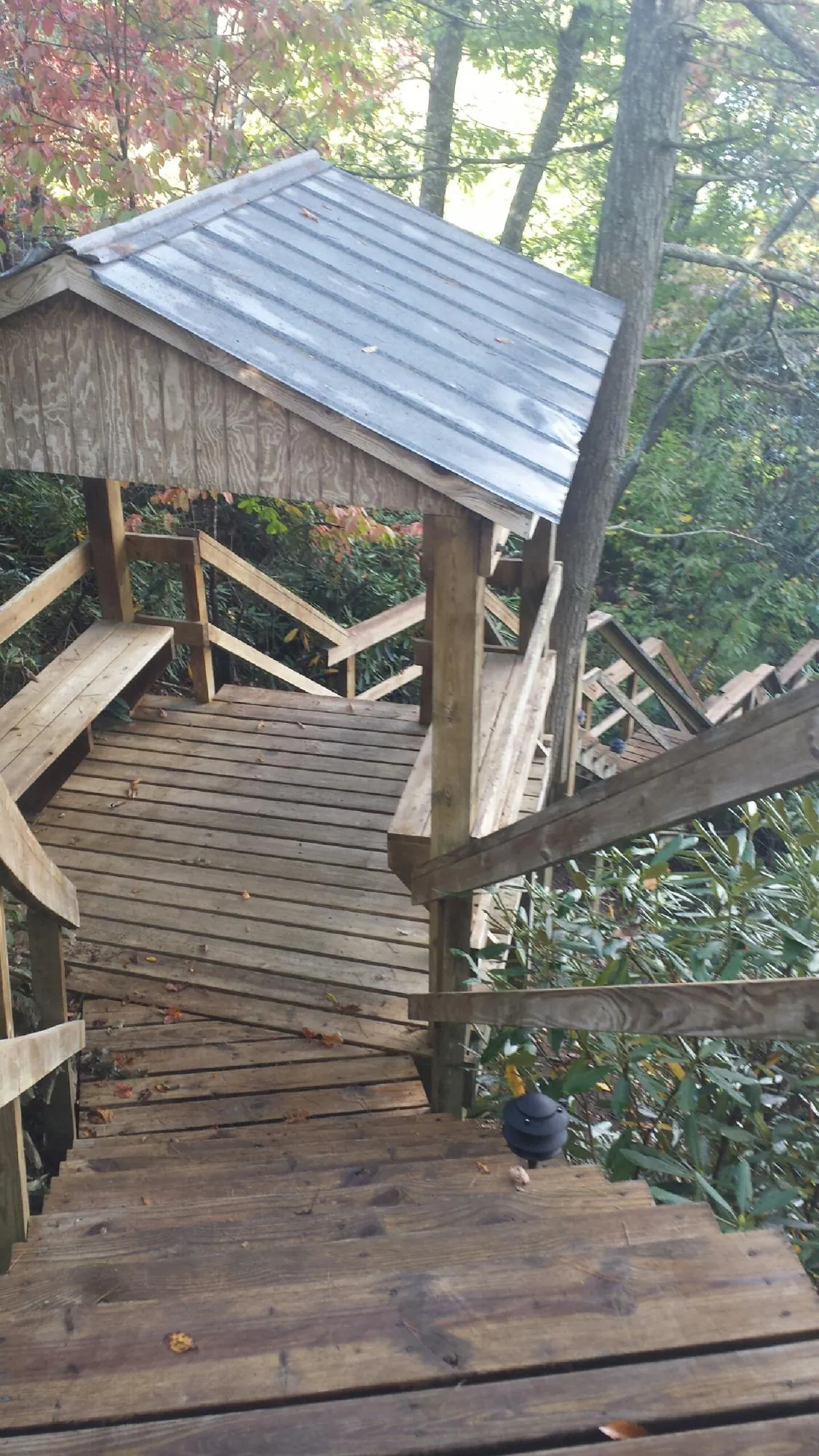 Metal roofed shelter over wooden steps on a wooded walkway — Skylight Repair & Installation work by our crew in Nanuet