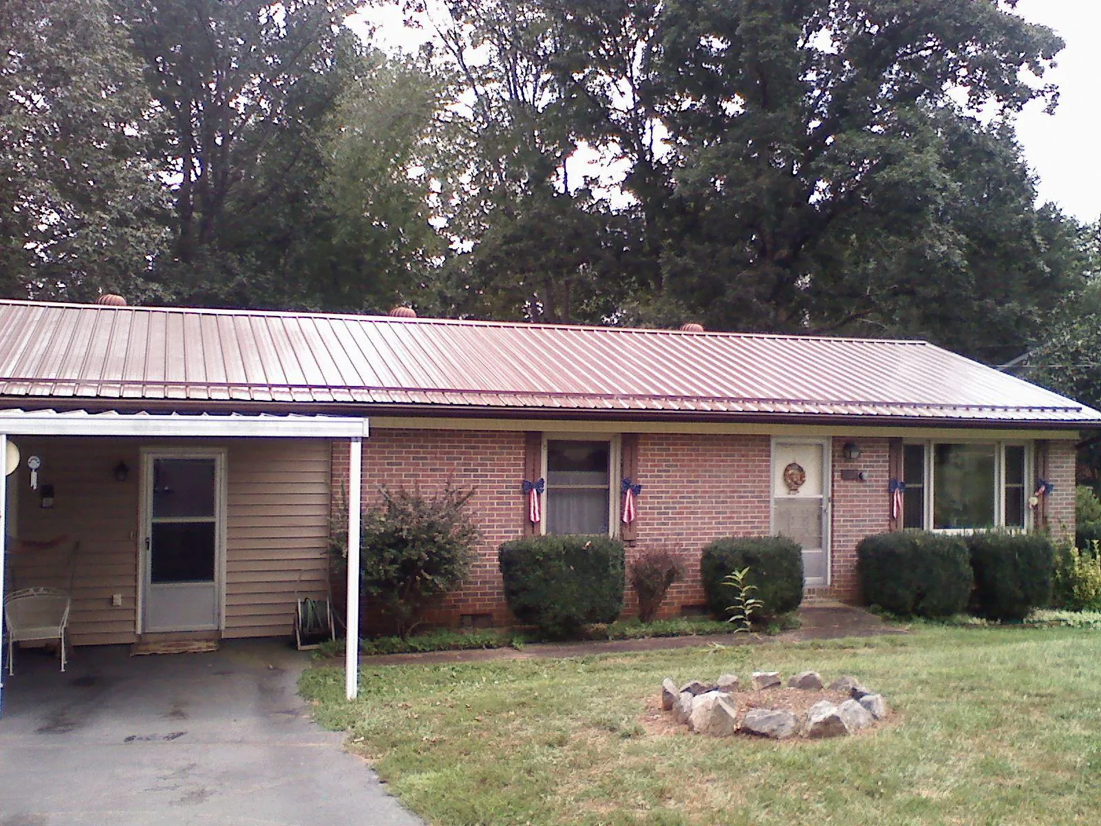 Bronze metal roof and carport on a brick ranch home — Roof Repair work by our crew in Nanuet